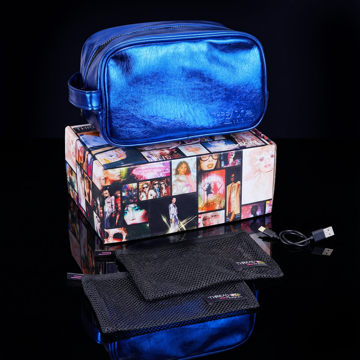 Ocean blue metallic LED travel makeup bag with USB charging cable and removeable mesh pouches on collectible Studio 77 gift box. Large vegan leather cosmetic organizer with rechargeable lighting and wipeable insulated lining by Thread Original. 