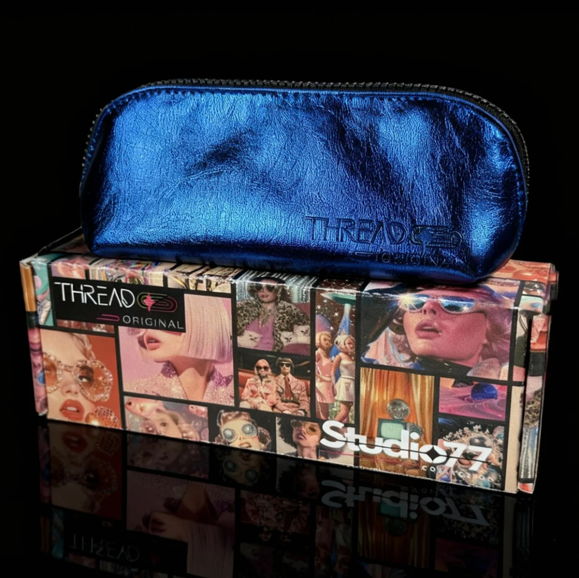 Closed Lyra makeup bag in metallic Ocean blue, displayed on top of a Thread Original box.
