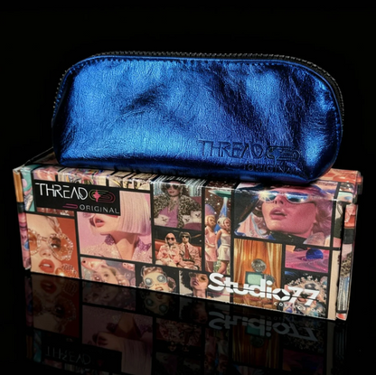Closed Lyra makeup bag in metallic Ocean blue, displayed on top of a Thread Original box.