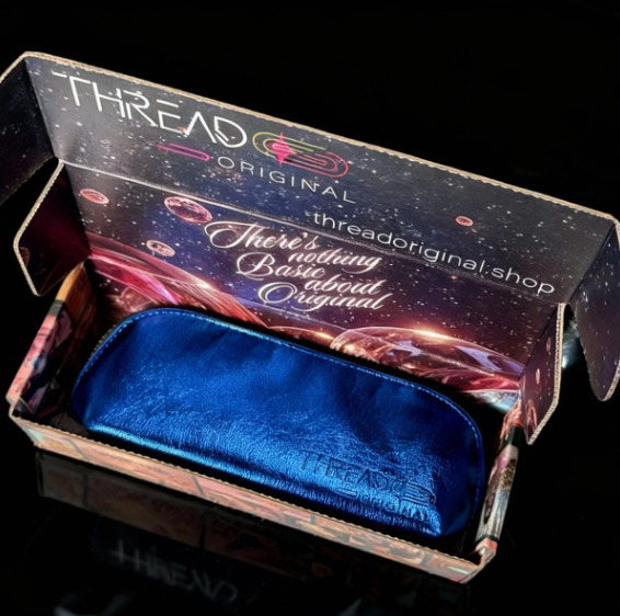Lyra compact makeup bag in metallic Ocean blue, displayed inside an open Thread Original gift box.